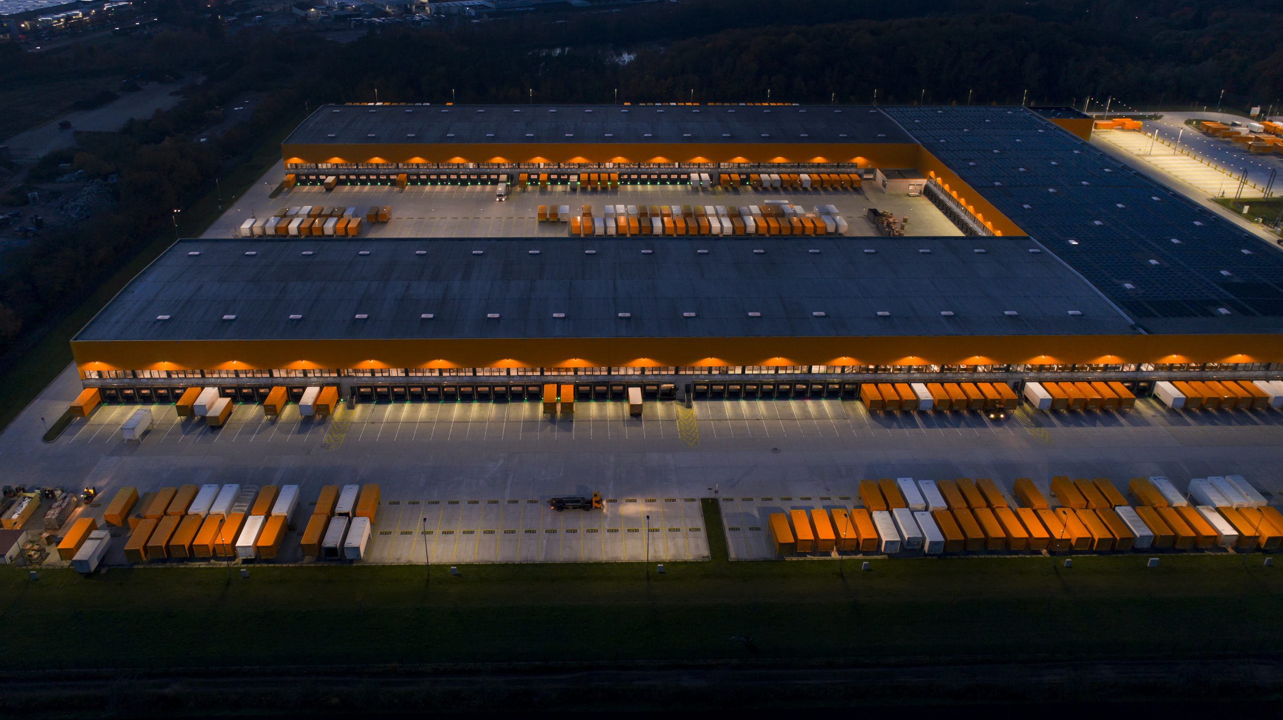 Large distribution hub, trucks and trailers - aerial view at dusk